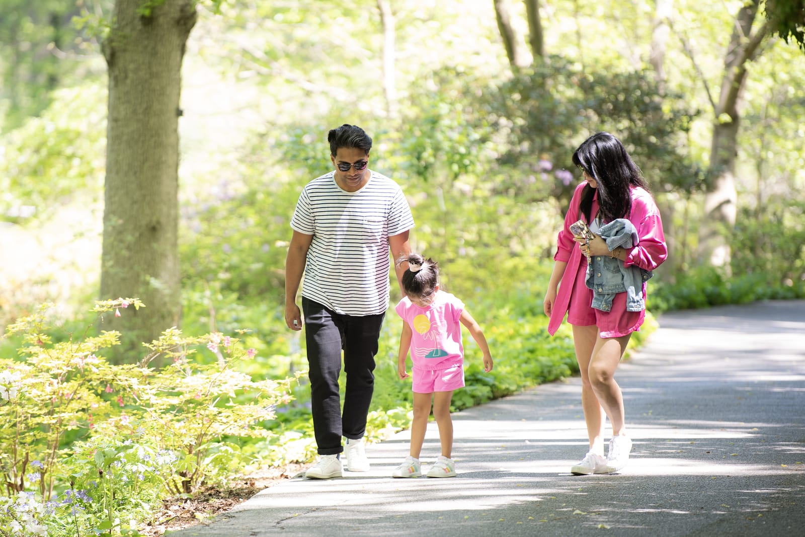 A family walking a shaded garden path at Jenkins Arboretum & Gardens