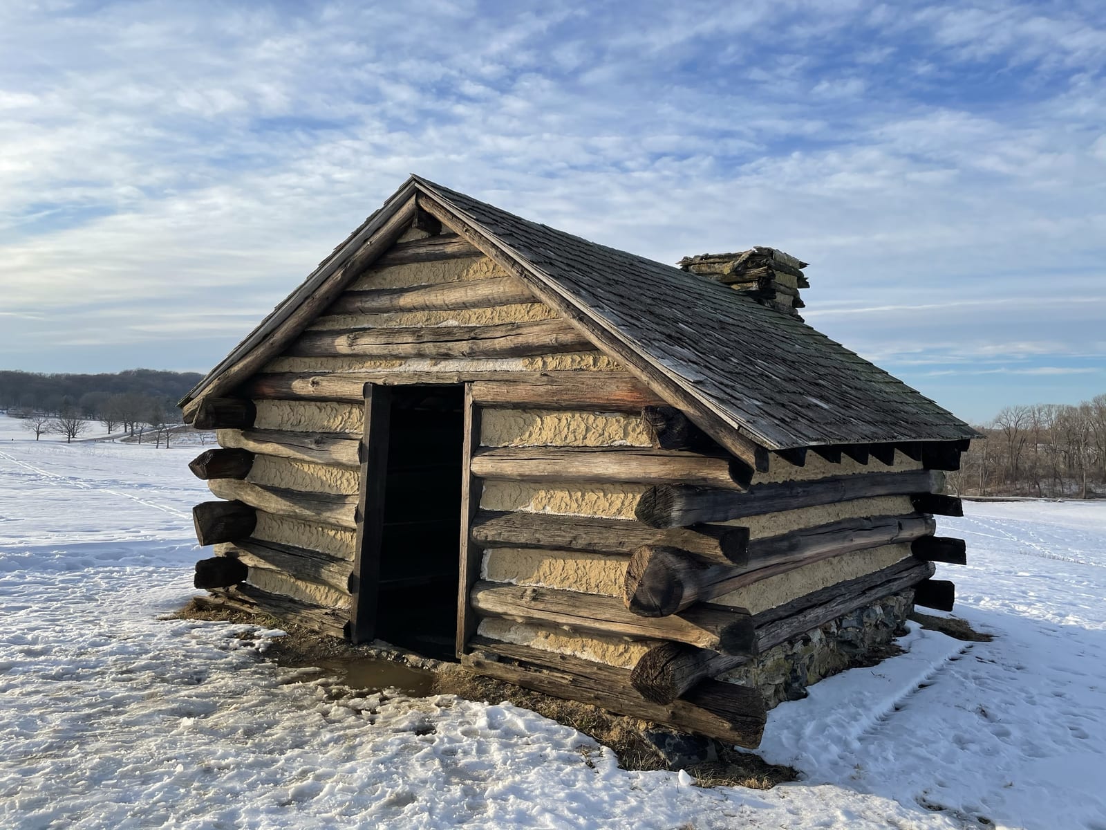 A reconstructed soldiers' log hut in the snow at Valley Forge