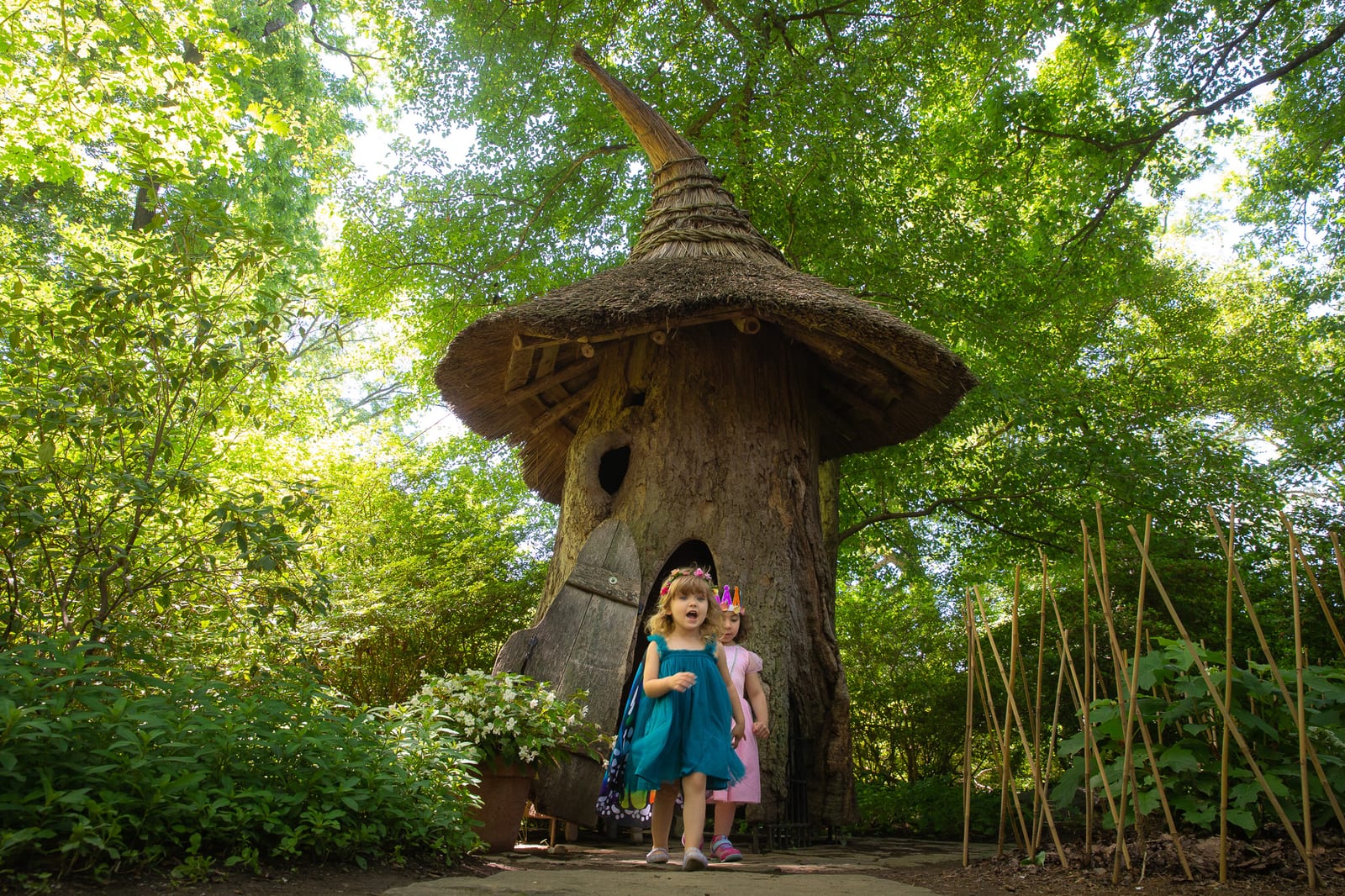 Two young children in fairy costumes at the thatched Tulip Tree House in Enchanted Woods, Winterthur